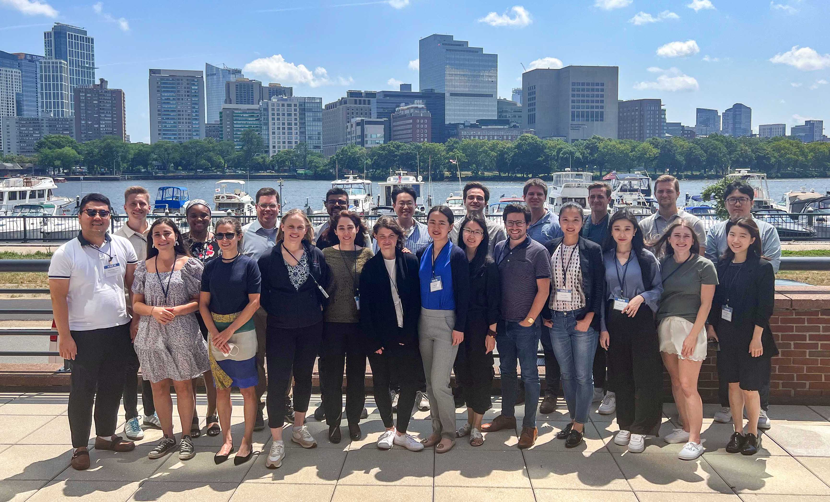 Group Photo of participants of NBER Innovation Boot Camp 2022 near the water with the boston skyline behind